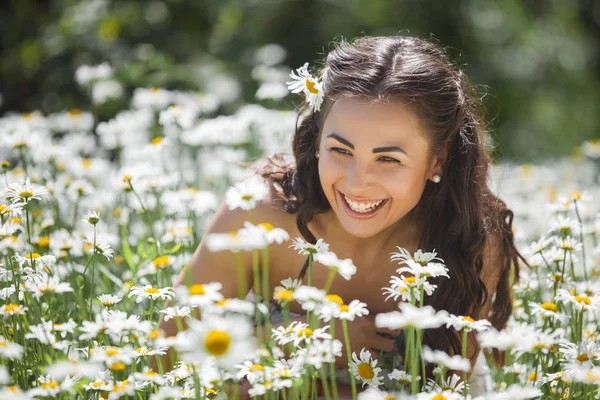 カモミール フィールド上の花に囲まれた若い女性 ロイヤリティフリーのストック画像
