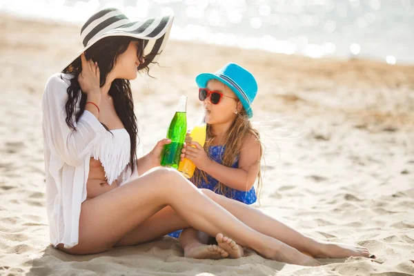 Joven Madre Con Hija Sentada Playa Bebiendo Limonada —  Fotos de Stock