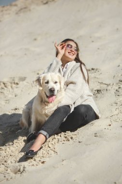 açık havada kumsalda yalan köpek olan kadın
