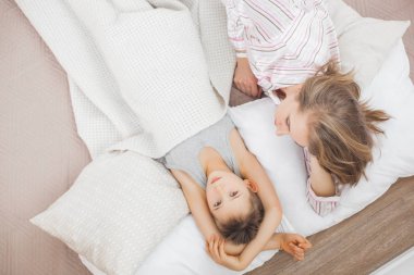 uykulu anne oğluyla beyaz battaniye altında yatakta yalan