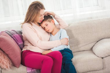 Mother trying to calming down son at home clipart