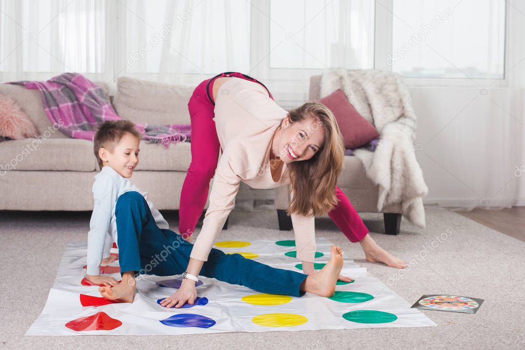 mother playing twister with son in living room