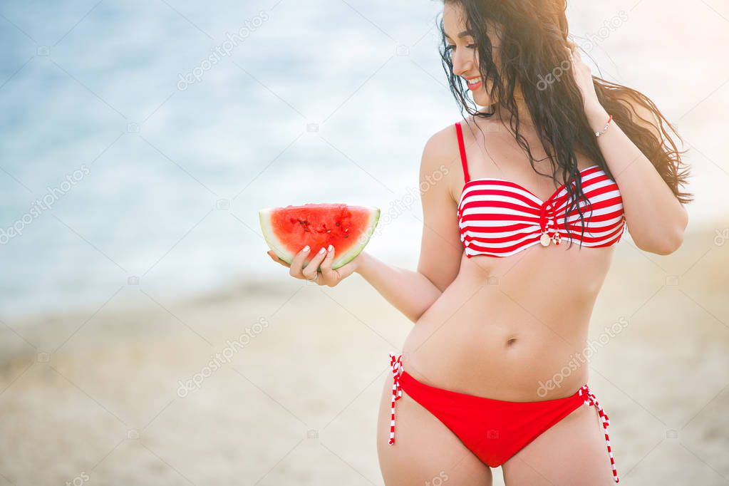 Young attractive woman on the beach relaxing. Pretty woman with watermelon. Cute girl outdoors
