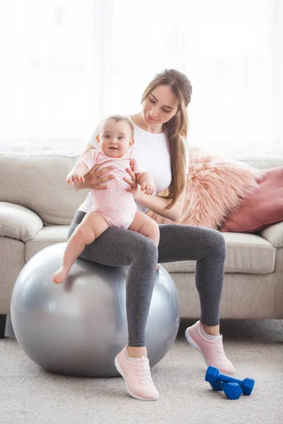 若いかなり母親は彼女の小さな子供を自宅でワークアウト — ストック写真