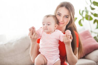 Pretty young mother holding her baby girl  clipart