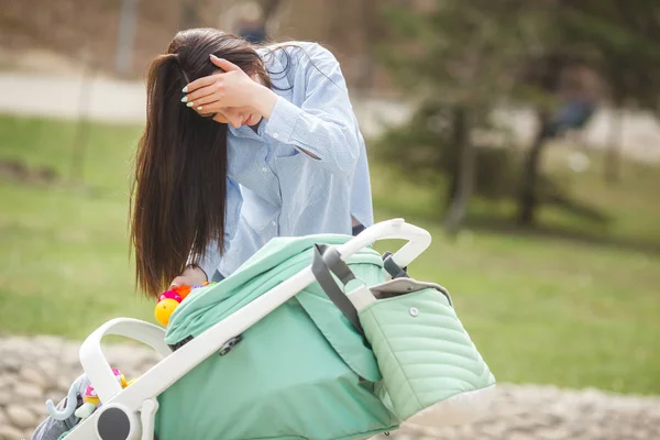 Young mother trying to calm down her little baby outdoors