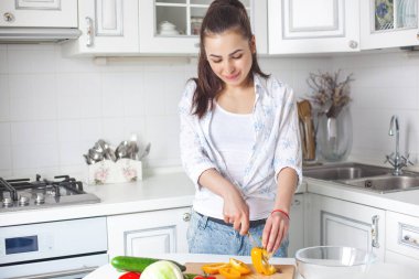 Genç çekici kadın yemek salata kapalı mutfak at