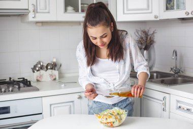 Genç çekici kadın yemek salata kapalı mutfak at