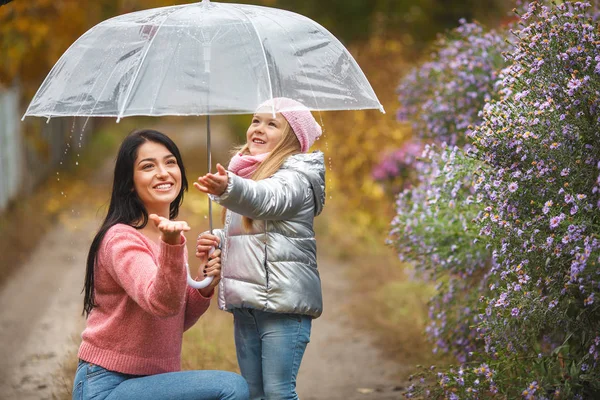 可爱的孩子与她的年轻母亲在秋季背景下的雨伞乐趣 愉快的家庭在秋天时间 — 图库照片