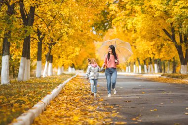 Neşeli kız sonbahar park togrther yürümek