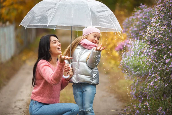 可爱的孩子与她的年轻母亲在秋季背景下的雨伞乐趣 愉快的家庭在秋天时间 — 图库照片