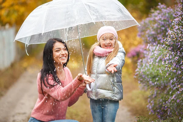 可爱的孩子与她的年轻母亲在秋季背景下的雨伞乐趣 愉快的家庭在秋天时间 — 图库照片