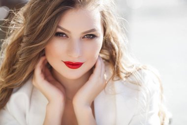 Açık havada genç ve güzel bir kadının portresi. Zarif bir yüz resmi. Sarışın kadın kameraya bakıyor ve gülümsüyor..