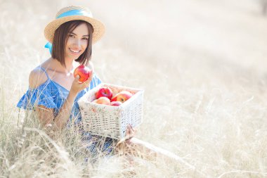 Yaz geçmişinde çekici bir genç kadın. Gülümseyen kadın portresi. Güzel bayan dışarıda elma tutuyor..