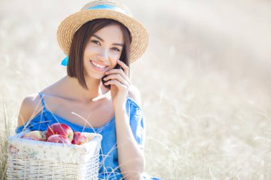 Yaz geçmişinde çekici bir genç kadın. Gülümseyen kadın portresi. Güzel bayan dışarıda elma tutuyor..