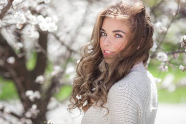 Bahar arka planında güzel bir bayan. Saçında çiçekler olan bir kadın. Doğuştan güzel geçmişi olan bir kadın..