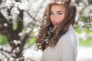 İlkbahar arka planında güzel bir kadın. Çiçekli arka planda güzel genç bir bayan..