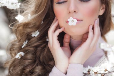 Bahar arka planında güzel bir bayan. Saçında çiçekler olan bir kadın. Doğuştan güzel geçmişi olan bir kadın..