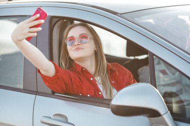 Deniz kıyısında araba süren genç ve güzel bir çift. Kadın ve erkek gezide eğleniyor. Otomobille seyahat edenler.