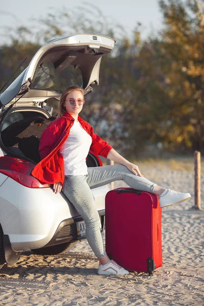 若いきれいな女性が車で旅行する 女性の運転車 スーツケースと旅行に行く女 — ストック写真