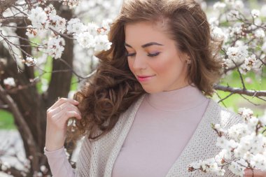 İlkbahar arka planında güzel bir kadın. Çiçekli arka planda güzel genç bir bayan..