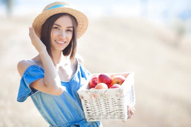 Yaz geçmişinde çekici bir genç kadın. Gülümseyen kadın portresi. Güzel bayan dışarıda elma tutuyor..