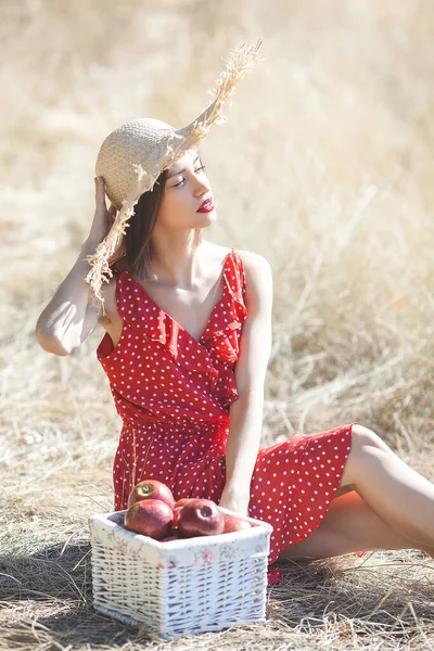 夏の背景に藁帽子をかぶった若い美しい女性の肖像画 自然界に新鮮なリンゴを持つ女性 — ストック写真