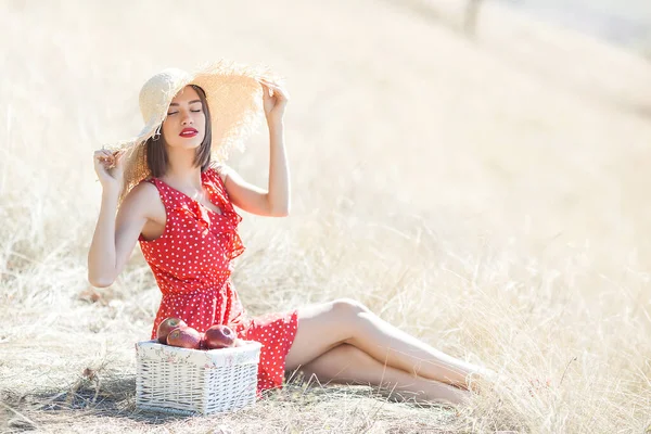 夏の背景に藁帽子をかぶった若い美しい女性の肖像画 自然界に新鮮なリンゴを持つ女性 — ストック写真
