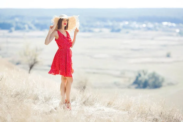 自然を背景に屋外の魅力的な若い女性 赤いドレスと赤い口紅を着た女性 美しい女性モデルのクローズアップポートレート — ストック写真