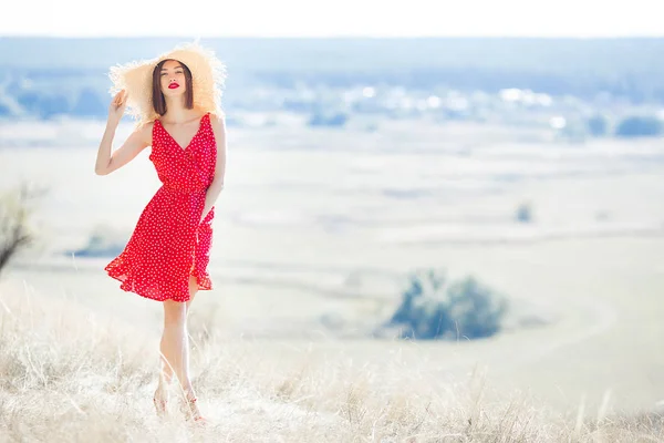 自然を背景に屋外の魅力的な若い女性 赤いドレスと赤い口紅を着た女性 美しい女性モデルのクローズアップポートレート — ストック写真
