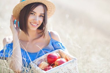 Yaz geçmişinde çekici bir genç kadın. Gülümseyen kadın portresi. Güzel bayan dışarıda elma tutuyor..