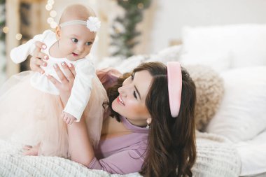 Küçük bebeğini taşıyan çekici bir anne. Annem tatlı çocuğunu kucağında tutuyor. Mutlu, genç bir aile.