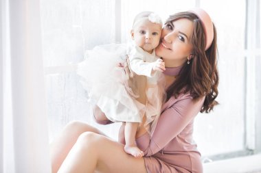 Küçük bebeğini taşıyan çekici bir anne. Annem tatlı çocuğunu kucağında tutuyor. Mutlu, genç bir aile.