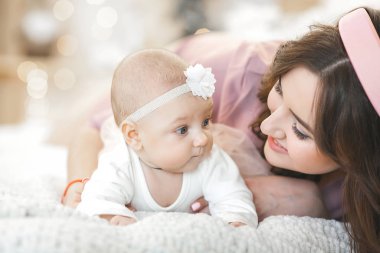 Küçük bebeğini taşıyan çekici bir anne. Annem tatlı çocuğunu kucağında tutuyor. Mutlu, genç bir aile.