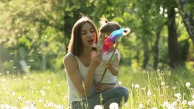 Sevimli anne ve kızı birlikte. Dışarıda mutlu bir aile. Çiçekli kızlar. yaz arkaplanındaki kadın ve çocuğu. Karahindiba tarlası.