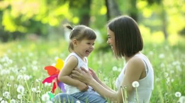 Sevimli anne ve kızı birlikte. Dışarıda mutlu bir aile. Çiçekli kızlar. yaz arkaplanındaki kadın ve çocuğu. Karahindiba tarlası.