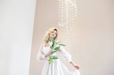 Çekici genç kadın portresi. İçeride güzel bir bayan var. Çiçek tutan kadın..