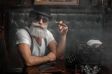 Yaşlı adam içeride puro içiyor. Mafya konsepti. Dolabında şık bir erkek. Sakallı adam..