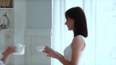 Anne ve yetişkin kız evde birlikte. Evde mutlu bir aile. Yetişkin bir anne ve yetişkin kızı birlikte takılıyor. Çay ya da kahve içen kadınlar.