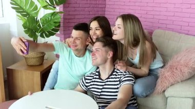 Genç insanlar içeride selfie çekiyorlar. Bir grup arkadaş akıllı telefondan çekim yapıyor.. 
