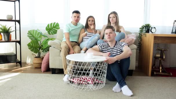 Grupa Młodych Ludzi Ogląda Telewizję Aktywna Młodzież Domu Dopingująca Drużynę — Wideo stockowe