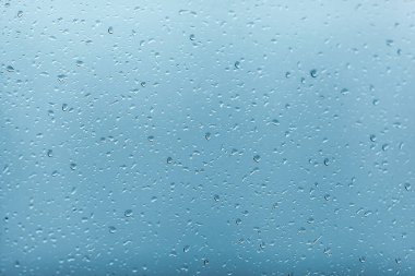 Pencereye yağmur damlaları. Bardakta su var. Koşan damla. Arkaplan kavramsal.
