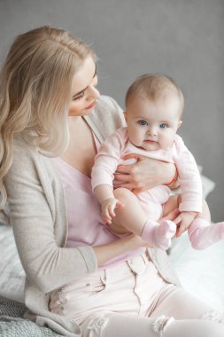 Küçük bebeği olan genç bir anne. Anne tatlı çocuğunu kucağında tutuyor. Annelik kavramı.