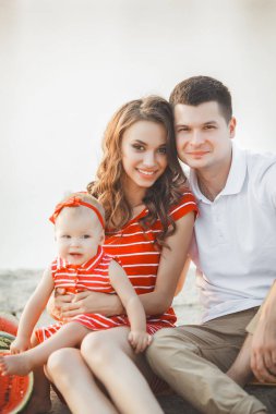 Kumsalda gün batımında sevimli bir aile. Yaz tatili. Aile birlikte eğleniyor..