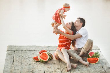Kumsalda gün batımında sevimli bir aile. Yaz tatili. Aile birlikte eğleniyor..