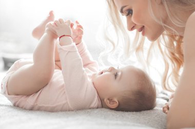 Küçük bebeği olan genç bir anne. Anne tatlı çocuğunu kucağında tutuyor. Annelik kavramı.