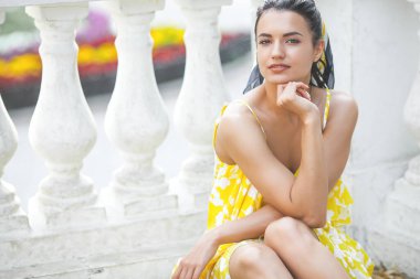 Güzel genç bayanın portresini yakından çek. Güzel bir kadın dışarıda yürüyor. Sarı elbiseli zarif bir kadın..