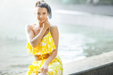 Güzel genç bayanın portresini yakından çek. Güzel bir kadın dışarıda yürüyor. Sarı elbiseli zarif bir kadın..