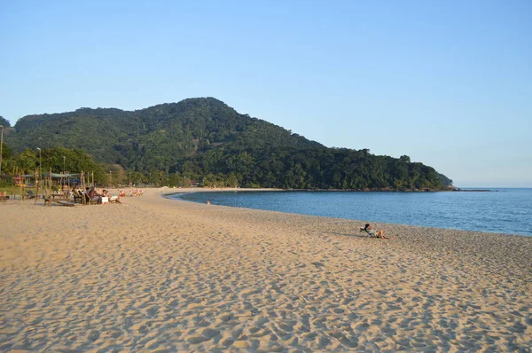 Gente esparcida por la arena en la playa — Foto de Stock