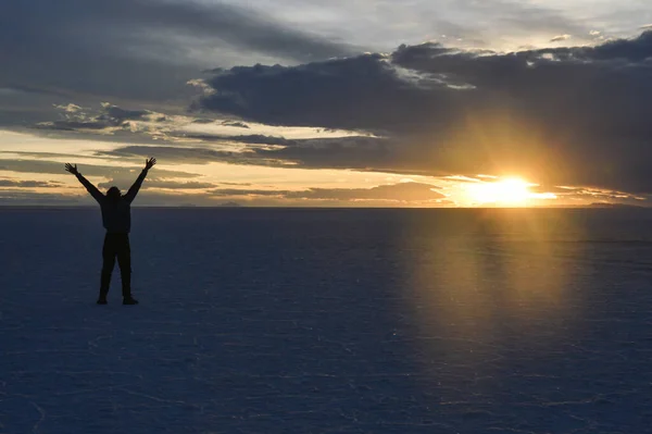 Одинокий Человек Соленой Пустыне Уюни Боливии Смотрит Закат Распростертыми Объятиями Стоковое Фото